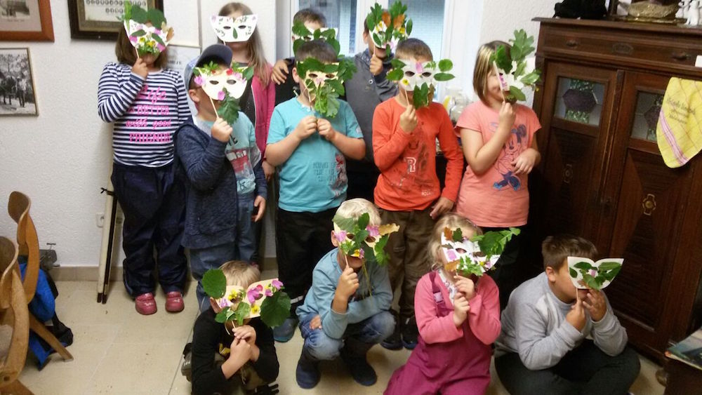 Die Kinder präsentieren ihre Waldgeistermasken von der Ferienpassaktion 2017 in Ahlshausen-Sievershausen